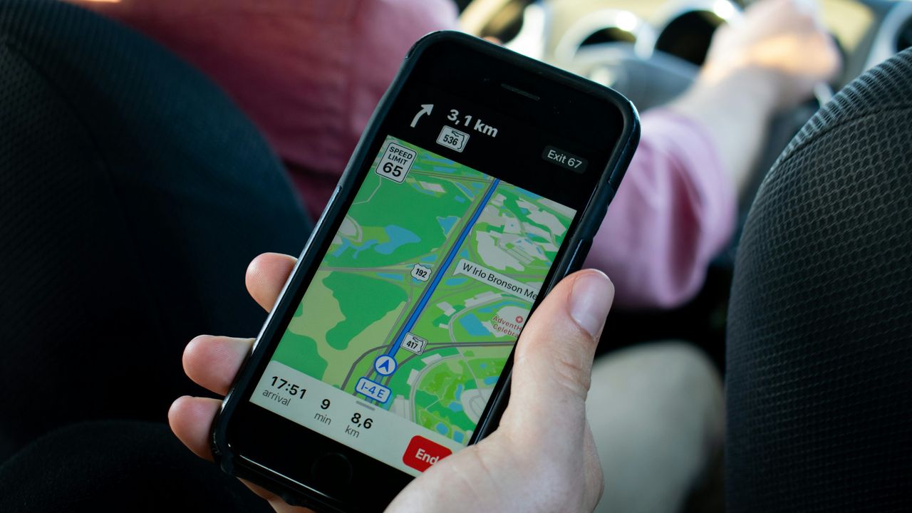 Mano sosteniendo un teléfono con un mapa durante un viaje