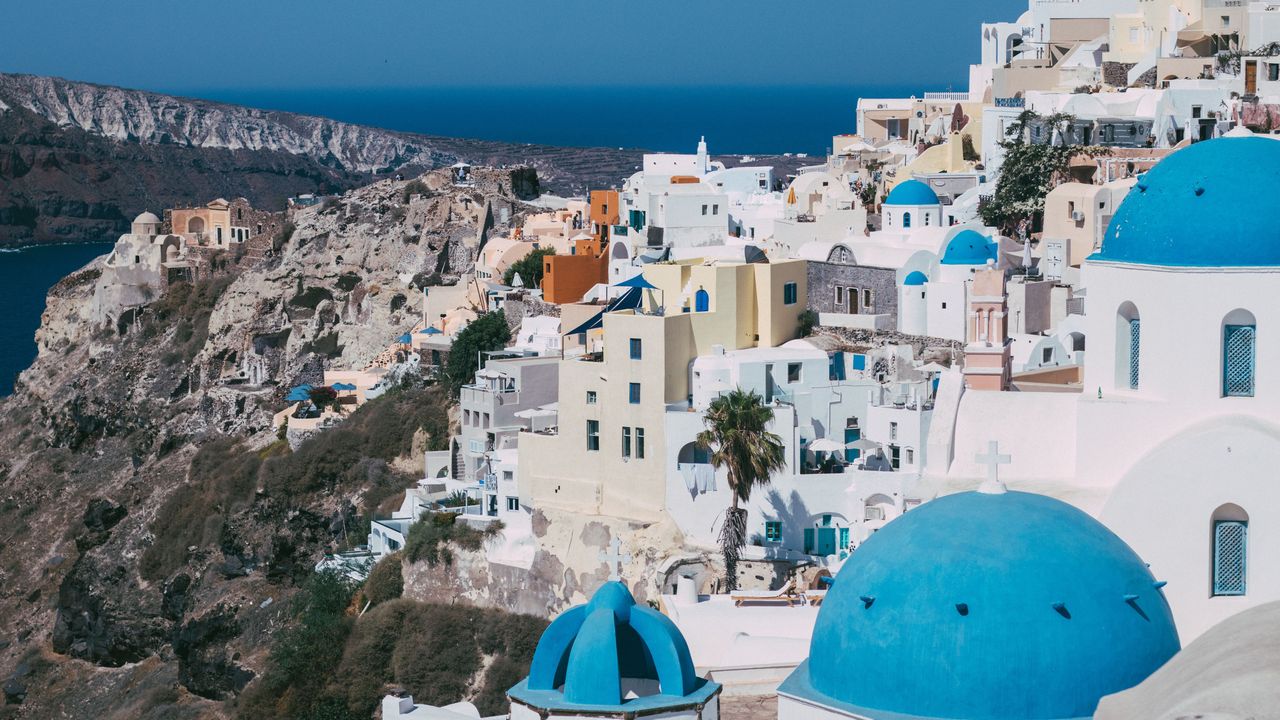Las casas blancas y las cúpulas azules de Oia en el acantilado de Santorini