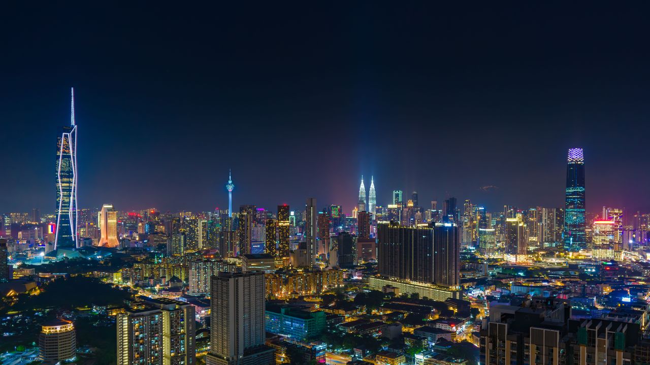 The Kuala Lumpur skyline at night with the Petronas Towers lit up