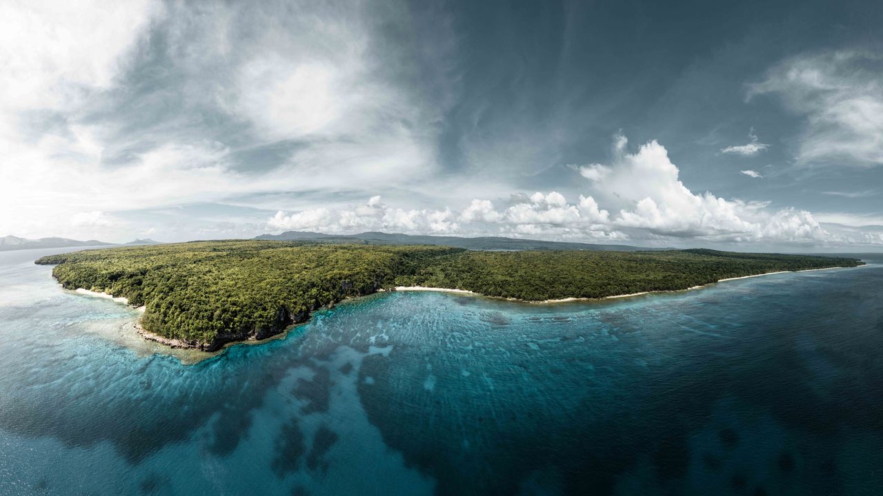 The green coastline and reef of Vanuatu from the air