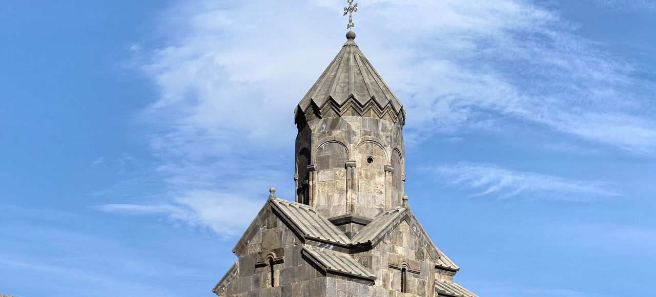 Historic medieval church in Tatev, Armenia under clear blue skies