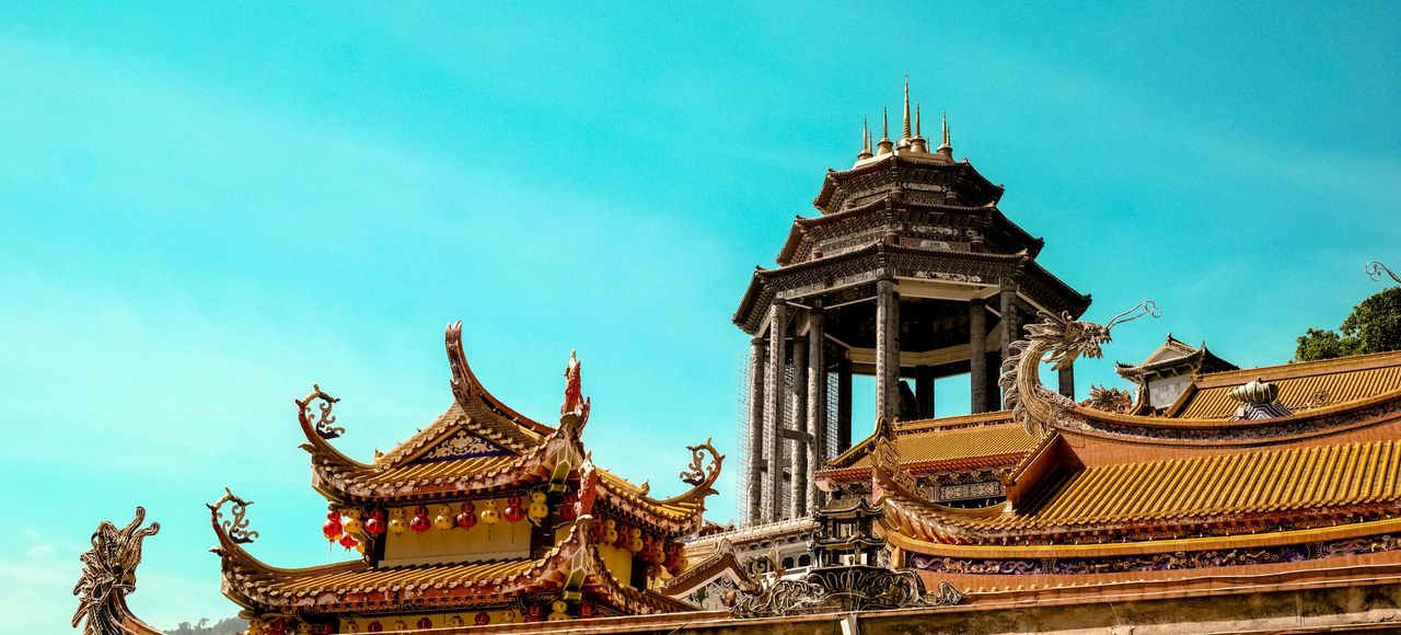 A stunning view of traditional Asian temple architecture set against a bright blue sky