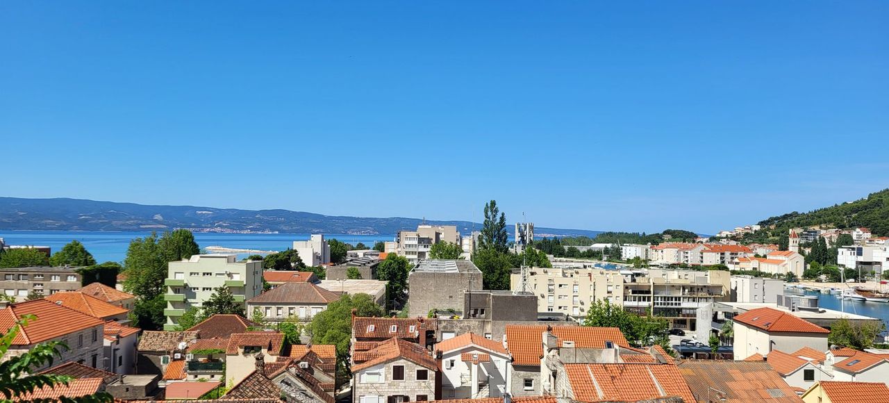 Balkans: Overlooking the terracotta rooftops of Omiš with the Adriatic Sea in the distance under a clear blue sky