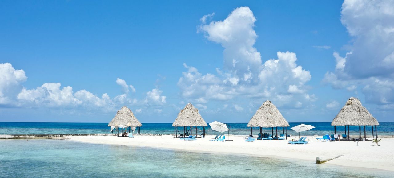 Peaceful tropical beach with palapas on a sunny day in Belize