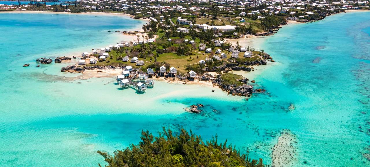 A stunning aerial shot capturing Bermuda's coastline with vibrant turquoise waters and charming houses