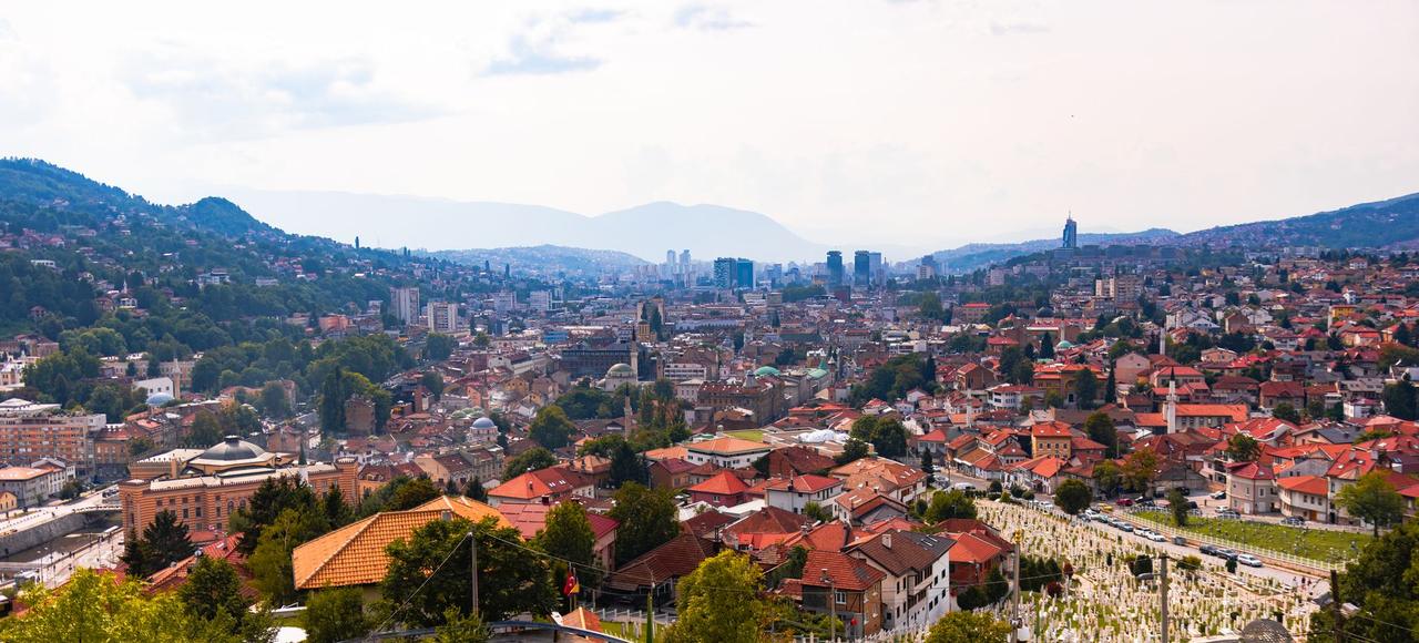 Bosnia and Herzegovina: Aerial view of Sarajevo, showcasing cityscape, red rooftops, and distant mountains