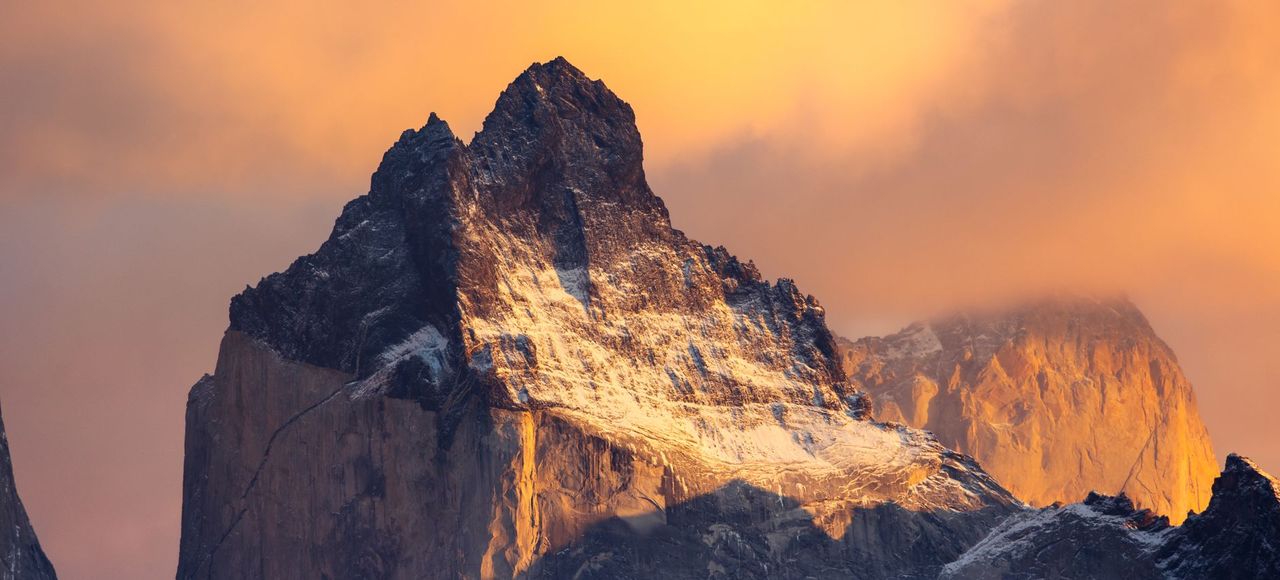 Chile: Breathtaking view of Torres del Paine at sunrise, capturing dramatic mountain peaks with orange and pink hues