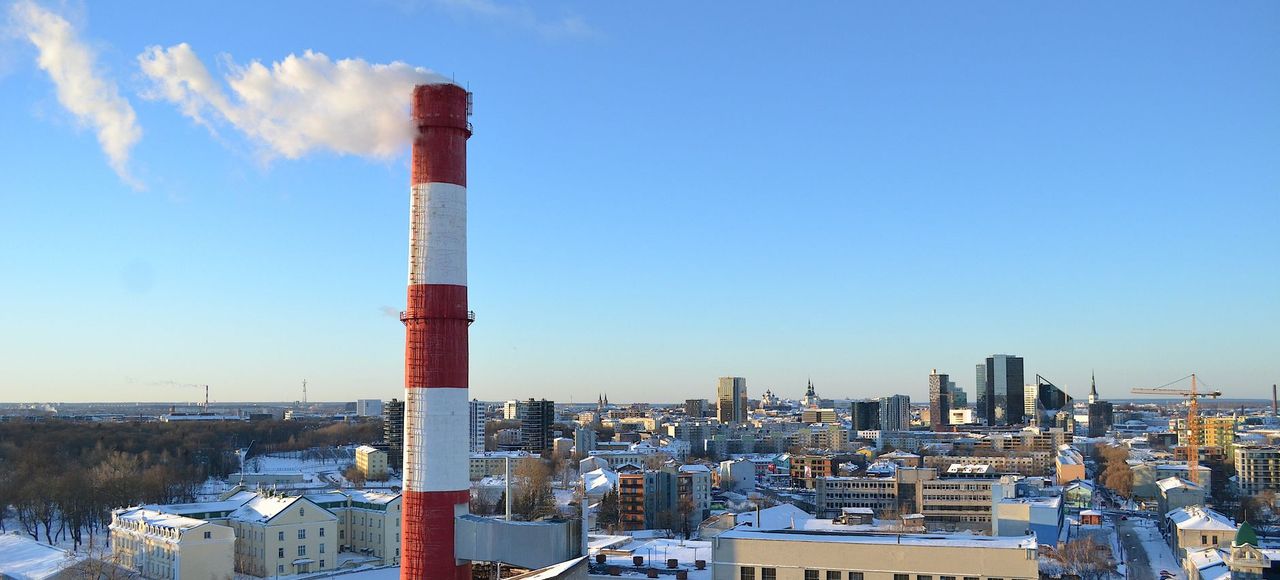 Aerial view of Tallinn in winter with snow-covered rooftops and a smoking chimney in Estonia