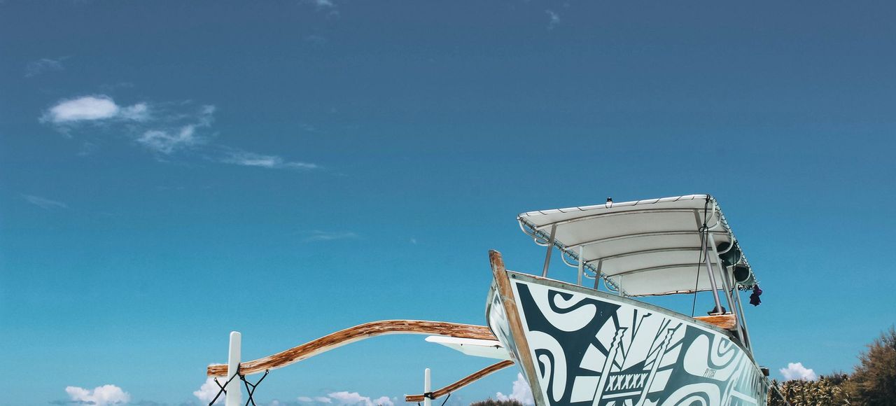Scenic view of a traditional boat in the turquoise waters of Vaitāpē, French Polynesia with blue skies