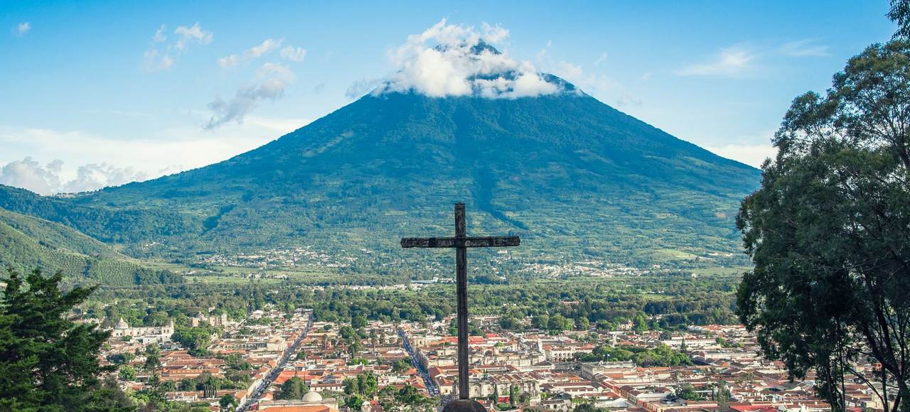 Scenic view of Antigua Guatemala with Volcán de Agua, featuring a prominent cross in the foreground