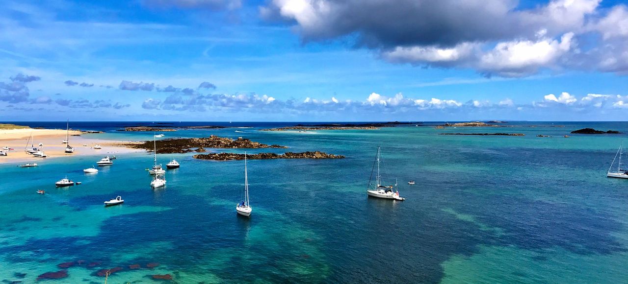 Beautiful seascape of Herm, Guernsey featuring sailboats on clear blue water with a vibrant sky