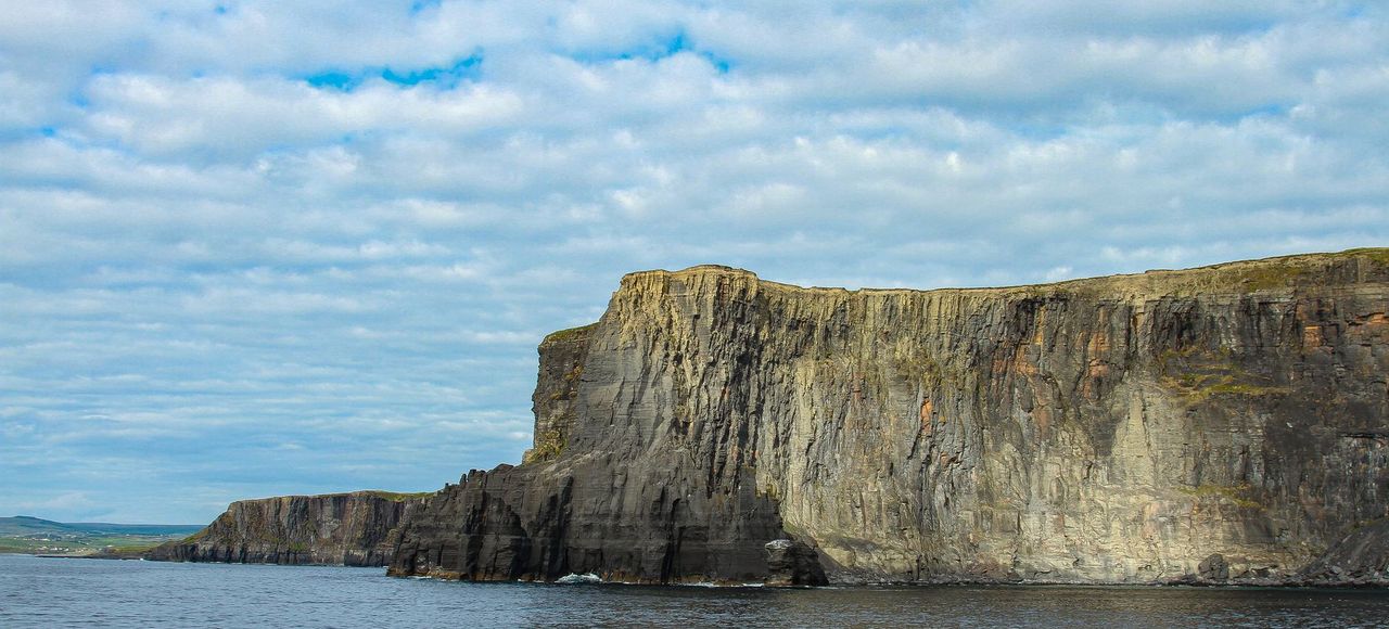 Ireland: Explore majestic sea cliffs with rugged beauty under a dramatic cloudscape