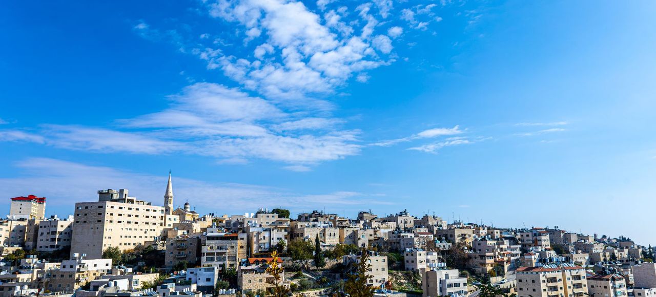 Israel: Beautiful panoramic view of Bethlehem cityscape under a vibrant blue sky, showcasing historical architecture