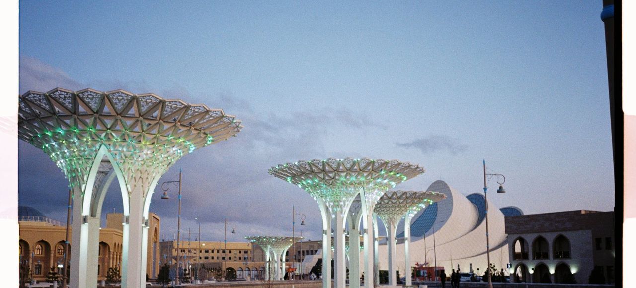 Kazakhstan: Futuristic urban landscape with modern architecture in Turkestan, featuring illuminated structures at dusk