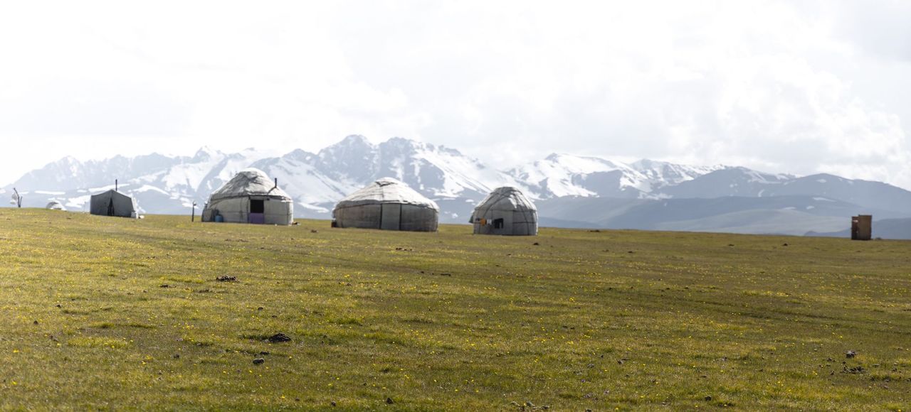 Kyrgyzstan: Traditional yurts in a mountain landscape under clear skies