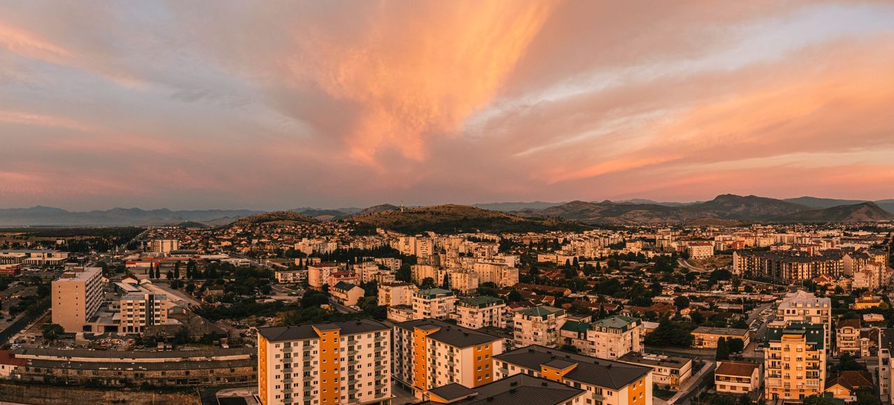 Scenic aerial view of Podgorica, Montenegro at sunset featuring vibrant skies and urban architecture