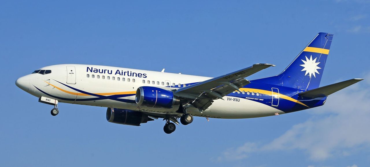 Nauru Airlines jet flying mid-air with a clear blue sky backdrop
