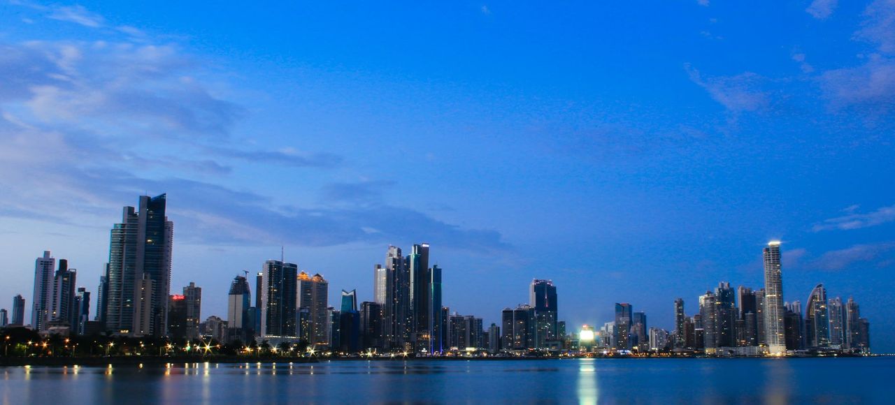 Stunning Panama City skyline with high-rise buildings and calm sea under a vibrant blue evening sky