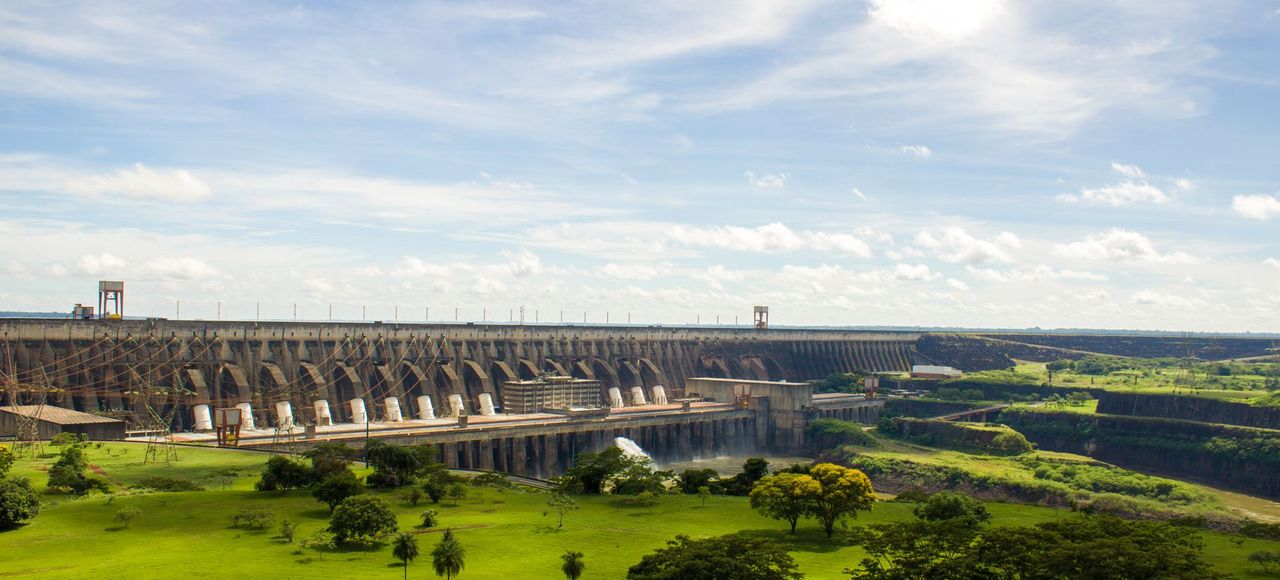 Paraguay: Experience the majestic Itaipu Dam surrounded by lush greenery in this scenic landscape view