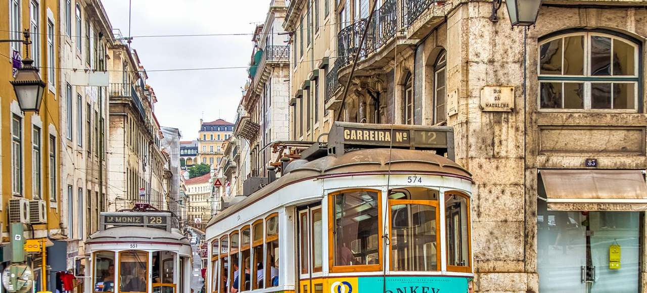 Portugal: Colorful trams on a vibrant street in Lisbon, showcasing historic architecture and urban life