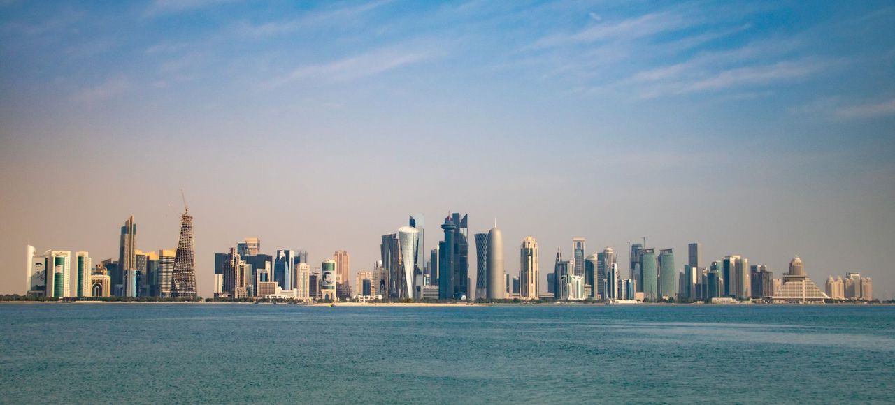 Qatar: Captivating view of Doha skyline from the Corniche, featuring modern architecture under a clear blue sky