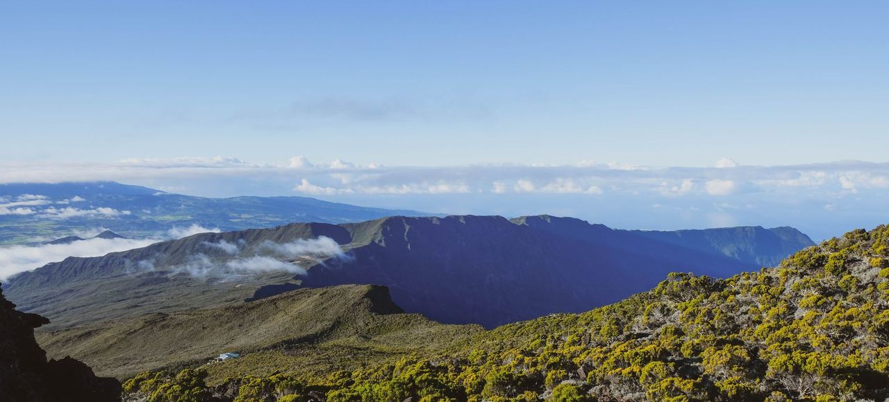 Stunning aerial view of a volcanic landscape on Réunion Island with lush greenery and clear skies