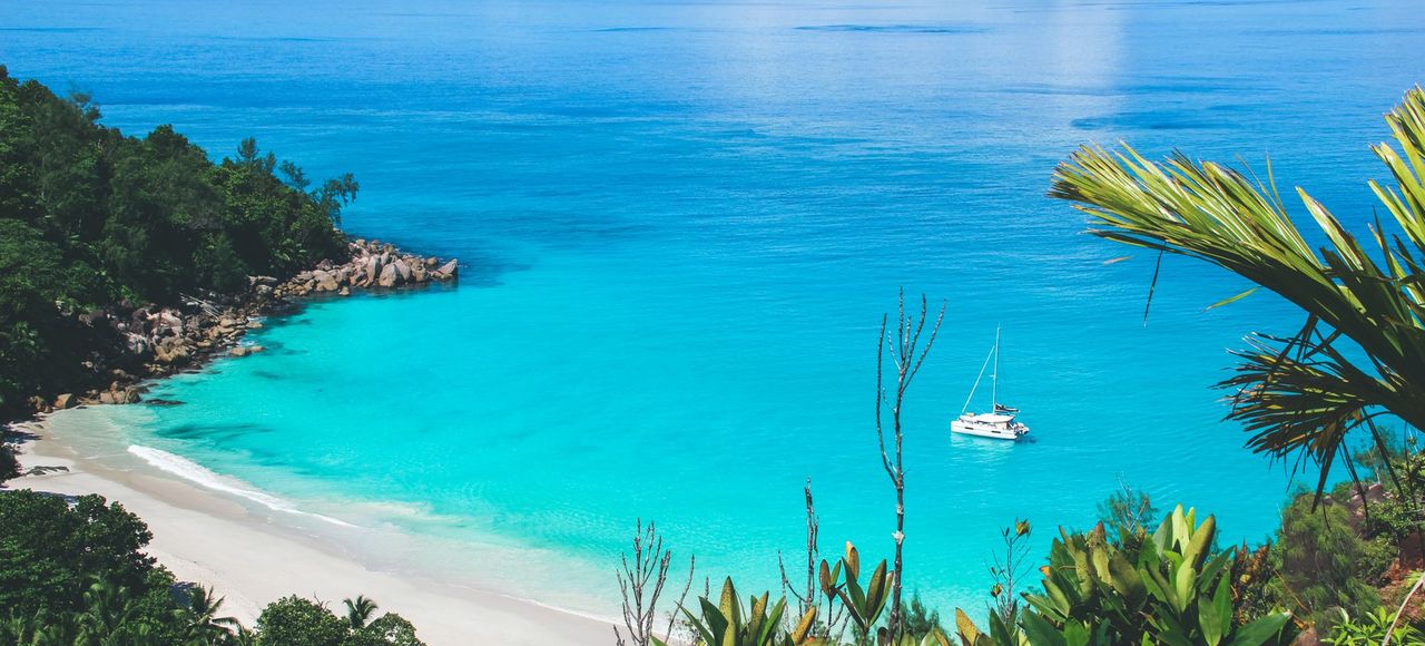 Stunning tropical beach in Seychelles with crystal-clear turquoise water and lush greenery