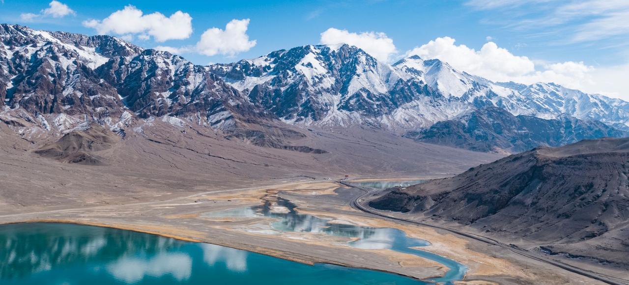 Tajikistan: A breathtaking aerial view of a Tibetan mountain range with a serene lake under a clear blue sky