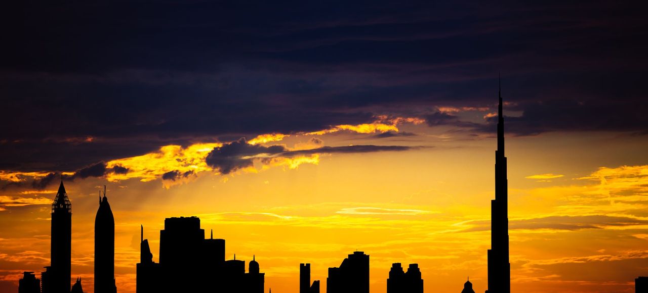 United Arab Emirates: Captivating silhouette of Dubai's skyline with vibrant sunset colors and Burj Khalifa dominating the scene